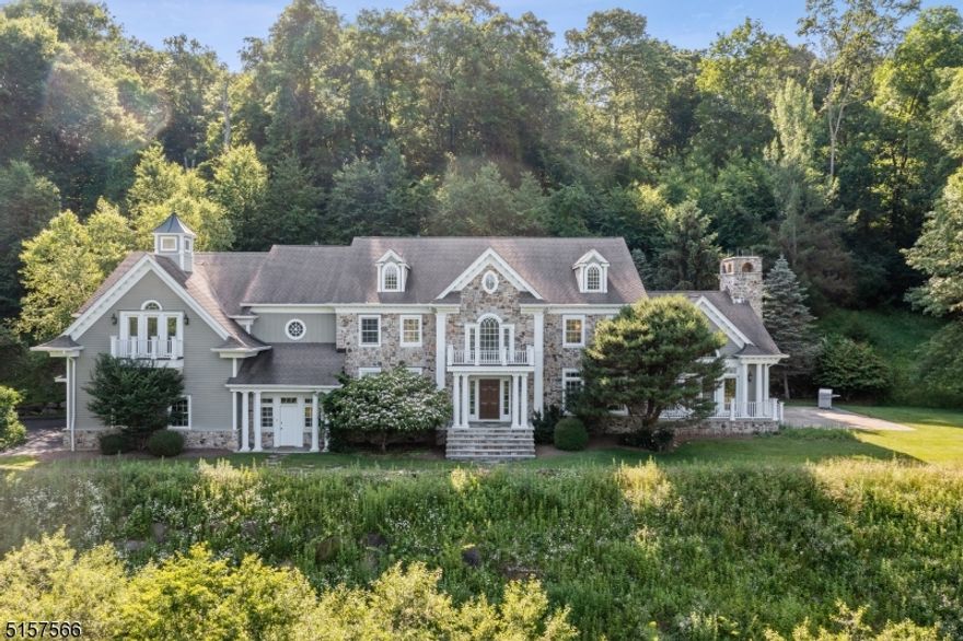 This custom home is elegant in its clean lines and understated design. From the custom and trim and moldings to the variable planked walnut hardwood floors, there is a feeling of openness and light. The study features a coffered ceiling and built-ins with custom molding on the walls. A potential bedroom on the first floor is currently being used as an additional office. The kitchen cabinetry is also walnut with marble counters and professional appliances. A light filled breakfast area is adjacent to the kitchen.  The fireplace in the family room, located off the kitchen, is floor to ceiling stone with a large wood burning, gas fired firebox. Doors from the family room open to the blue stone flat side yard. Exquisite light fixtures throughout, especially in the oversized dining room which also features a fireplace. The primary bedroom has a sitting area with double doors to the balcony, perfect for catching the morning sunrise. The primary bath has a gorgeous terrazzo tile radiant heated floor. All bedrooms are ensuite. The walk up third floor is the perfect recreation area with room for a pool table and media/gaming space. The basement is finished and features an exercise room and ample sized climate controlled wine cellar. The home is on a private gated drive for maximum privacy. Four car oversized garage. Stone accent landscape wall. Built with structure for an elevator. Blue Ribbon school district.  Easy access to Rt 78