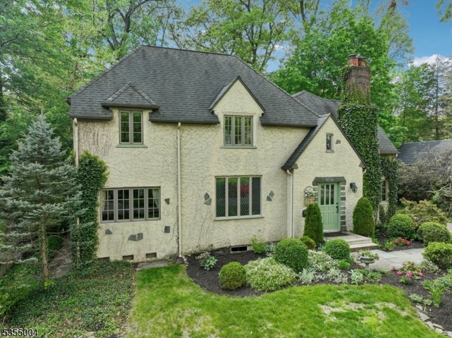 Elegant and charming, this c.1928 French Normandy-style Tudor is nestled on a private 0.40-acre lot in the desirable Knollwood section of Short Hills. Impeccably restored and maintained, this home blends classic architectural details with modern updates. Notable features include thermal leaded glass windows, a soaring cathedral ceiling with Juliet balcony, original wood-burning fireplace with marble hearth, and gleaming hardwood floors throughout. The first floor boasts a gracious living room with refurbished vintage chandelier, formal dining room with custom built-ins, and a comfortable family room.The renovated kitchen features Artistic Tile natural slate floors, KitchenAid refrigerator, DW & double electric wall ovens, Fisher & Paykel 5-burner gas range, and a center island open to the breakfast room.A marble powder room, office/homework room, mudroom, and attached 2-car garage with storage complete the main level. On the second level are four bedrooms and two new full baths, including a primary suite with Bisazza Italian tile, Schonbek crystal light fixture, and terrazzo flooring.The lower level includes a recreation room, workroom, laundry, storage, and updated powder room.Two exits lead to a Trex deck and slate patio overlooking lush, deep landscaped gardens.Just 3 blocks from Millburn's top-rated middle and high schools, and near both Millburn and Short Hills train stations.Enjoy the vibrant Knollwood community, known for block parties and its beloved Halloween Parade!