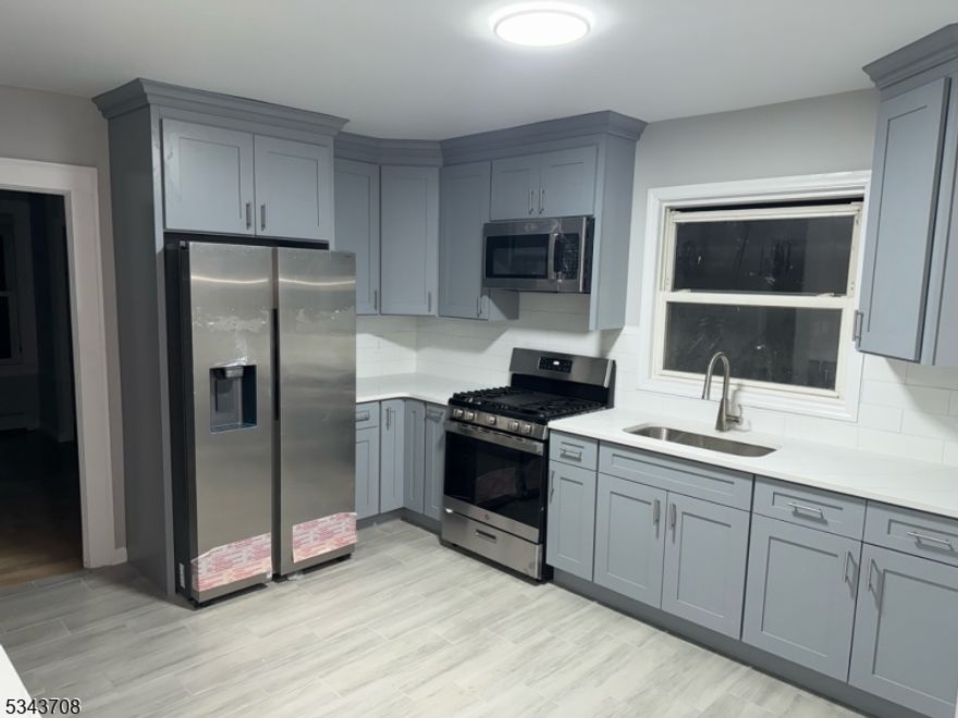 This beautifully renovated 1st floor offers 3 bedrooms, living room dinning room and kitchen, hardwood flooring and tile brand new kitchen with quarts counters new appliances and ALL UTILITIES INCLUDED IN RENT.  laundry in basement very nice unit, make this your new home.