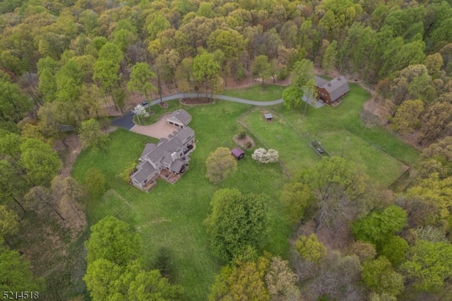 Cliffwood Farms is the quintessential lifestyle farm featuring 65 private wooded acres; the perfect place to relax and recharge. The main residence and barn are designed in a Post-and-Beam style that complements the natural surroundings. The property offers a wide variety of activities including hiking, horseback riding, gardening, and raising livestock. The home, built in 2014, captures the feeling of a relaxing getaway. The two-story Great Room with an impressive floor-to-ceiling stone fireplace is the centerpiece of the home. It's open to both the Kitchen and Dining areas, as well as a Wet Bar, making it a perfect place for entertaining guests or simply relaxing fireside. The 1st floor also includes the Primary Bedroom with a luxurious en-suite bath, a dedicated Home Office, and  Laundry Room.  Upstairs there are three additional Bedrooms, two Full Baths, Loft and Study. The unique Gambrel Style Post and Beam Barn satisfy both work and leisure needs with a 5 stall barn, radiant heated observation room including wet bar, half bath, and additional loft space. The sprawling yard and wooded acreage with trails and nature views make Cliffwood Farms a truly special property.  It is the perfect escape from the demands of daily life. Enjoy the tranquillity of country living while just minutes away from Mendham and Chester Boros.