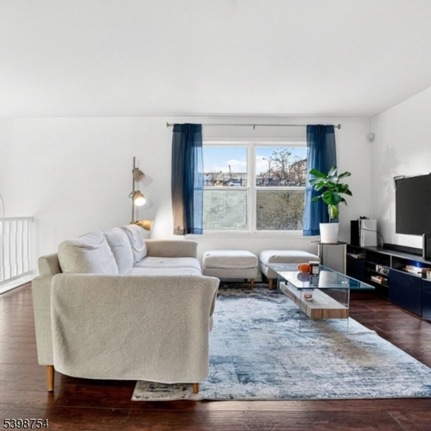 Rare opportunity for multi-level townhouse living in the heart of Teacher's Village. This beautifully updated two-bedroom, two-and-a-half-bath home delivers the comfort and functionality today's lifestyles demand, highlighted by a built-in garage, driveway parking, and private outdoor space. The ground level features an inviting foyer, a dedicated laundry area, and a versatile bonus room ideal for a home office, guest space, or flex use, with direct walkout access to the shared backyard. The main living level offers a bright, open layout anchored by a wood-burning fireplace and a defined dining area, creating a natural flow for everyday living and entertaining. The stylish kitchen is equipped with stainless steel appliances, an electric glass-top range, and modern wood-style flooring that runs throughout the space. Upstairs, the primary suite serves as a private retreat with a walk-in closet and en-suite bath, while the second bedroom is complemented by a full hall bath, offering excellent separation. Additional highlights include central air, a private deck, and an unbeatable location near Newark Penn Station, Rutgers, NJIT, and Whole Foods, providing easy access to NYC while maintaining a true neighborhood feel.