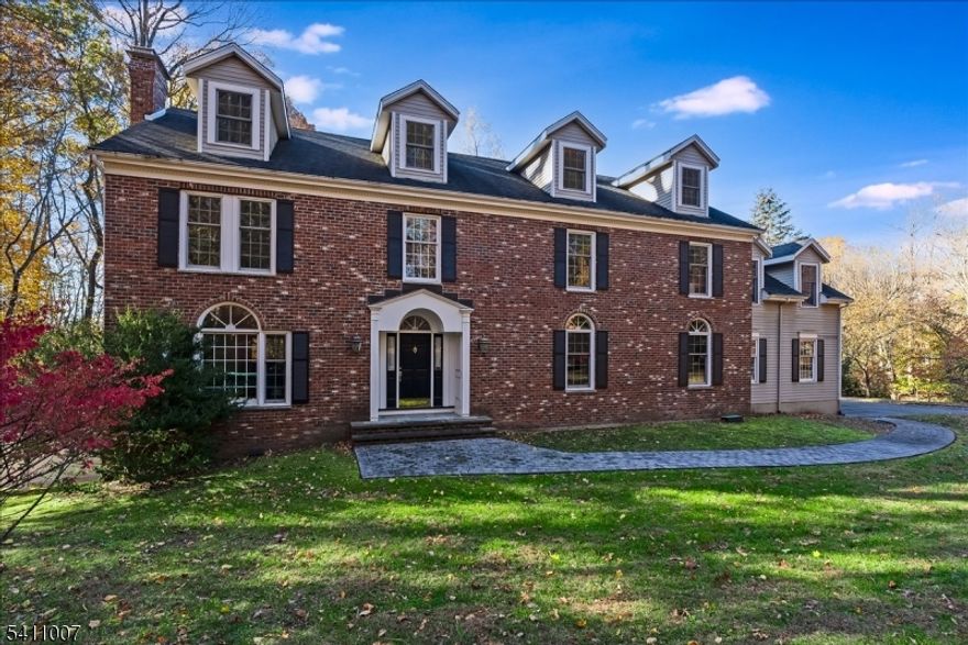 Stately Colonial with 5 bedrooms and 6.5 baths, beautifully maintained throughout. A gracious foyer with detailed moldings opens to expansive living and dining rooms, ideal for entertaining. The designer kitchen offers abundant cabinetry, a fabulous sitting room w/ fireplace, breakfast area w/ backyard views, butler's pantry, dual sinks, beverage center, warming drawer and newer dishwasher and cooktop, flowing seamlessly into adjoining bright large family room with bay window. The first floor also features a private office and a distinguished den with custom built-ins. The spacious primary suite includes a dressing room, elegant bath, and private solarium overlooking the wooded yard. Additional bedrooms are generously sized with excellent closet space. The full walkout lower level includes a kitchenette, recreation space, exercise area, workshop, full bath and flexible living options. A large walk-up attic provides future finishing potential. An elevator services all levels, offering exceptional convenience. Additional features include first floor full bath and powder room, second floor laundry, monitored alarm system, three-car attached garage, large deck and private yard. Seller improvements include upgraded exterior walkways, select replacement windows, replaced roof, 2019 hot water heater, garage doors and motors replaced and replaced 3 HVAC units. Located on a beautiful street in a quiet neighborhood near parks and convenient to the train station.