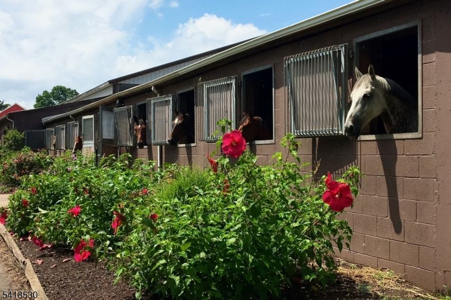 Close to downtown Princeton, this preserved farm with beautiful mature-trees and turnkey equestrian facilities tells a story that stretches back nearly half a century. Through decades of devotion, the same owners have transformed it into one of the region's most thoughtfully designed equestrian and preserved farm properties available today. At its center stands a meticulously maintained 28-stall stable, ventilated and crafted for any equestrian discipline, with a viewing lounge complete with a half bath and office. The original barn still has many stalls but could easily be converted into any farm use. A large outbuilding with oversized triple bay entry houses the farm equipment and machine shop while the surrounding land unfolds into many pastures and paddocks all with secure board fencing, equipped with automatic waterers and three run-in sheds that can be easily moved. Two Olympic-size sand arenas, a four-horse walker, and a round pen are ideal for any equestrian discipline. A path leads directly into the Cherry Brook Preserve with miles of trails. The farm is just 2.2 miles from Princeton Show Jumping which hosts major shows. A charming farmhouse, set behind a private gated drive, includes two bedrooms, an office with a fireplace, a large mudroom, a family room with a stove, a heated sunporch, and a generous dine-in kitchen.