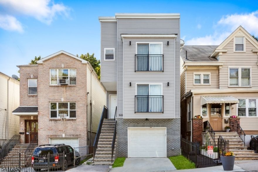 Experience this modern 2-Story home with garage in prime urban location! Welcome to this contemporary, low-maintenance home featuring a sleek exterior and thoughtful design. The property offers total of 8 bedrooms and 5 bathrooms with a private driveway leading to a built-in garage, providing convenient off-street parking. The elevated main entrance sits atop a wide staircase, adding privacy and enhancing curb appeal. Inside, the home boasts multiple levels of living space highlighted by large sliding glass doors with Juliet balconies that bring in abundant natural light. The modern facade includes clean lines, stylish gray siding, and brick accents on the lower level for a polished look. This property is ideal for homeowners or investors seeking a modern residence in a centrally located neighborhood near shops, transportation, and local amenities. Move-in ready and designed for easy living, this home offers the perfect blend of style, comfort, and convenience. Don't miss out on this exceptional opportunity!