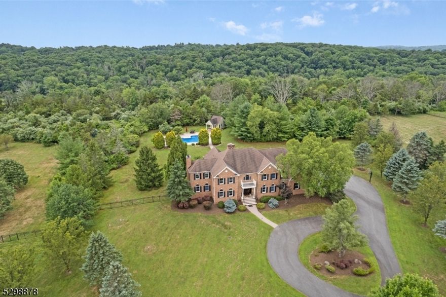 Absolutely breathtaking brick-front Colonial set back superbly on 14.66 acres in a coveted Roxiticus Valley estate neighborhood w the added pedigree of a Far Hills mailing address.  16 rooms, 5 bedrooms, 5 full & 2 half baths, 3 gas fireplaces, with an exceptional floor plan and perfect flow--nearly 5,700 sq ft of luxury living on 2 floors plus a fantastically finished lower level w kitchenette, full bath, exercise and recreation room.  Private fenced in yard offers newer expansive deck with hot tub plus I/G, heated  saltwater pool w concrete pool decking and convenient pool house with changing room/full bath & shower and serving area w sink and storage. Oversized 3-car attached garage. Professionally landscaped pancake-flat property.Impeccable craftsmanship, immaculate condition, and move-in ready!