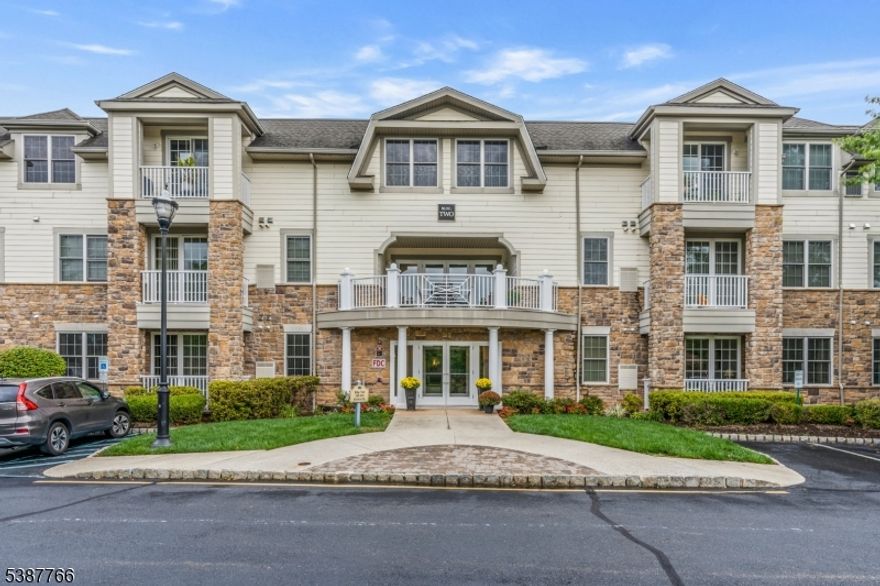 Welcome to this First Floor 2 bedroom, 2 bath condo located in the desired Four Seasons at Bridgewater 55+ Community. Upon entering you will be greeted by a bright, airy layout that flows seamlessly from one area to the next. The kitchen features 42" custom cabinetry, ceramic backsplash, stainless steel appliances and breakfast bar with an open-pass through that connects to the Dining Room & Living Room creating a perfect open floor plan. Living Room has sliders to open air balcony. The primary suite includes 2 closets; one of which is a walk-in. Luxurious primary bathroom offers a double vanity, walk-in shower with built-in seating. Additional large bedroom with double closet space. Full bath, laundry room complete this home. Additional features include hardwood flooring, recessed lighting, crown molding, high ceilings. AC (2022), hot water heater (2020). Enclosed underground parking with elevator access and assigned parking, extra storage area. Resort style amenities include stunning Clubhouse w/fireplace, bar, exercise room, library, card & billiards room plus outdoor heated pool, bocce ball. A welcoming garden w/barbeque area, paver patio. Excellent location w/easy access to shopping. Bridgewater Mall, restaurants and major highways. SELLER TO PAY ROOF ASSESSMENT AT CLOSING.