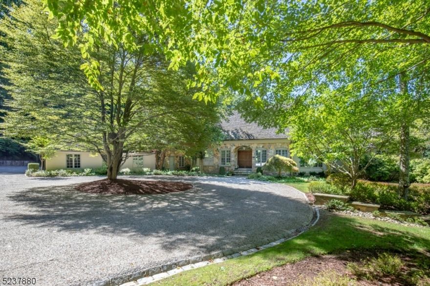 One of the most private estate settings on the Bernardsville Mountain was once part of the extensive Engelhard holdings. As the land drifts gently away from a private cul de sac it merges with a glorious wooded glen. The bridle trails are still marked as they meander along a stream and are now private walking paths. In 1983 architect Al Bol designed a home that complemented this sublime property. Using fieldstone similar to that found in the circa 1897 pump house, now renovated and overlooking a small natural pond, the home is finished in natural materials like a wood roof and fieldstone siding. A large stone terrace crosses the rear of the house and wraps around a pool tucked out of sight. Landscape architect Brian Bosenberg designed the landscape which is beautifully integrated into its natural surroundings. Inside, the front entry opens into a two-story great room with a Palladian window wall overlooking the stone terrace. To the left, the kitchen with eating area is highlighted by a wall of stacked stone and a fireplace. A charming sun room adjoins. The 1st floor primary suite offers 2 full baths, 3 walk-in closets and an adjacent office. Upstairs, there is a second primary bedroom, 2 additional bedrooms and a full bath. This arrangement has worked well as a private cluster of rooms for guests. A finished, walkout lower level includes an expansive family/media room, a spacious exercise room, a delightful naturally-cooled wine cellar and a full bath. Sq ft per tax records.