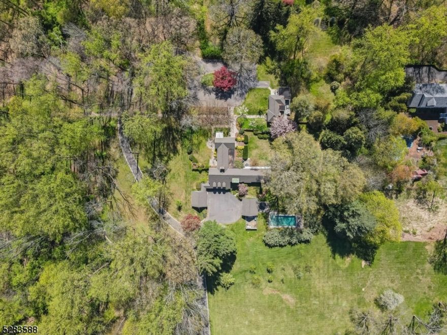 This custom mid century modern exquisite residence enjoys architectural elegance with exceptional attention to detail and was built on a portion of the Scribner estate on 6.2 stunning acres with mature trees, specimen plantings, tree lined pathways, reflecting pond, stone courtyard, pool and blue stone patios and cottage. The front elevation enjoys a circular drive with a dramatic entrance into the main residence with 5 bedrooms and 4 full baths. A gallery leads you to the living room and dining room with a wall of windows enjoying a view of the courtyard, blue stone patio and reflecting pond. The kitchen has a modern flair and enjoys a breakfast bar and stainless steel appliances and a view of the valley. The private quarters consists of a first floor primary wing offering peace and tranquility with bedroom, walk in closet, full bath, private library with fireplace, green house and blue stone patio. An additional wing of bedrooms includes 3 bedrooms, 2 full baths one ensuite and a laundry room. Continue to the ground level that features a family room, bedroom currently being used as an office, full bath, storage and access to the 4 car garage. The cottage offers a separate living space and enjoys a bedrooms, 2 full baths, kitchen, dining room, and a dramatic family room with cathedral ceiling, wood paneling, gas fireplace and two patios. Truly a great opportunity to enjoy a private space to live, relax and enjoy entertaining in ease inside and outside!