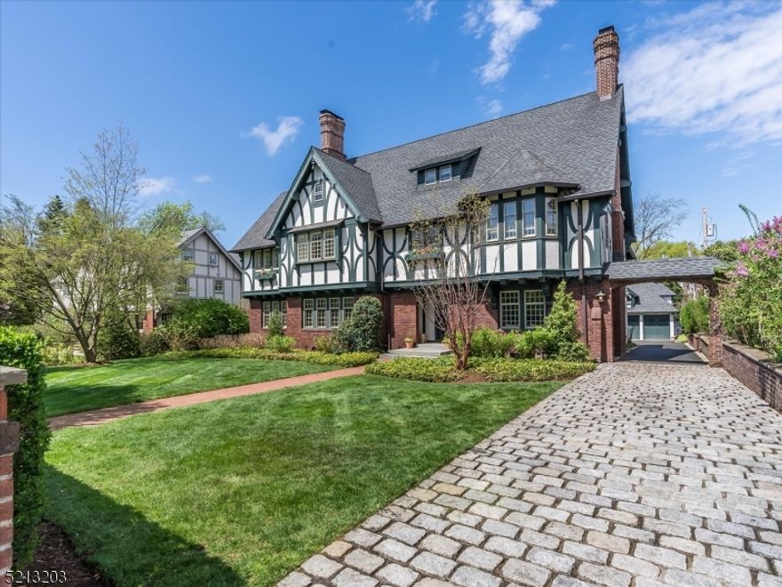 This notable residence offers wonderful craftsmanship and quality design in a truly outstanding location. The home has been renovated with such attention to detail and includes a gorgeous color palette which nods to European design. Outstanding wallpaper and custom lighting throughout. Gracious foyer welcomes you with exquisite woodwork, gorgeous moldings and incredible architectural detail including built in bookshelves and window seats. Exceptional first floor highlighted by large scale rooms including liv rm with fireplace and French doors to den/sunroom. Gracious formal dining rm is an entertainers dream w/newly renovated butlers pantry with wet bar, marble counters, dishwasher and stunning cabinetry. The state of the art kitchen features high end appliances, inset cabinetry, marble center island and separate sunny dining area. Mudroom with storage galore off the kitchen. Hotel-like primary suite features large, mahogany bath with double sinks and convenient laundry, walk in closet the size of a bedroom w/ center island and connecting office/sunroom. Move right into this luxurious home located close to everything Montclair has to offer. Lushly landscaped property with mature plantings and expansive bluestone patio offers complete privacy yet 2 blocks to shops, restaurants, movies, Starbucks. Carriage house above 3 car garage w/ separate entrance and utilities houses a bedroom, full bath and kitchenette. Perfect for guest quarters or separate office space, Simply stunning!