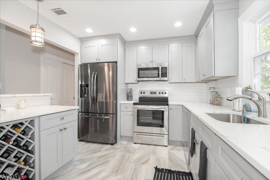 Warm, welcoming, and impeccably updated 4-bedroom, 2-bath home where modern design meets everyday comfort including public sewer and public water!!!  Step inside, be greeted by an open, airy layout highlighted by soaring vaulted ceilings and an abundance of natural light. The heart of the home is the stunning, updated kitchen, thoughtfully designed with timeless grey shaker cabinetry, elegant quartz countertops, a stylish complementary backsplash, and sleek stainless steel appliances?perfectly suited for both daily living and effortless entertaining. The adjoining dining area features newer sliders that open to an oversized deck, seamlessly blending indoor and outdoor living while overlooking a private, fully fenced backyard?ideal for gatherings, quiet mornings, or simply unwinding at the end of the day.Throughout the home, you?ll find freshly painted interiors, beautifully refinished hardwood floors, and updated trim and doors that add a crisp, modern touch. The main level bathroom has been tastefully renovated with custom tile work and high-end fixtures, offering a spa-like experience. downstairs, the flexible layout continues with a convenient first-floor bedroom, a full bathroom, and a spacious family room that opens directly to the rear patio perfect for guests, or a private retreat. With major updates already completed, including newer heating and cooling systems, plumbing, and electrical, this home offers true peace of mind and turnkey living.