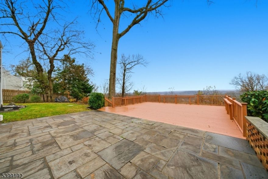 Experience one of the most breathtaking views in Morris Township - see the NYC skyline and get front-row seats to 4th of July fireworks from your living room. 66 Skyline Dr. offers space, style, and scenery in a beautifully maintained 5-bed, 3.5-bath home set in a highly sought-after neighborhood. The first level features brand new hardwood floors and a bright open-concept kitchen/living room with a brand new kitchen including quartz counters, stainless steel appliances, recessed lighting, and a freshly cleaned wood-burning fireplace. A formal dining room and family room sit just off the kitchen, creating a comfortable flow for everyday living and entertaining. Three bedrooms including a primary suite with private full bath  are located on the main floor, along with a powder room, laundry room, two-car garage access, and a living room with panoramic skyline views. Upstairs offers two additional bedrooms, a flexible loft/office space, and an updated full bath. The finished basement adds an office, bonus room, and rec area as a potential gym, playroom, or media space. Outside, enjoy a newly painted rooftop-style deck overlooking sweeping views, plus a private yard with mature landscaping/sprinklers. With newer HVAC, roof, gutters, windows, public water/sewer, central A/C, Hunter Douglas window treatments, and two walkouts to the yard, this move-in-ready home sits minutes from Downtown Morristown and major commuting. Homes with views like this are rarely offered - don't miss it.