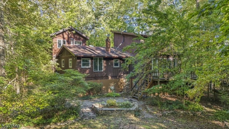Set on over 3 acres of mature woods in W Amwell, right on the Hopewell border, this home offers an elevated, nature-wrapped setting that truly feels like living in a tree house. Sunlight filters through the trees, wildlife wanders by, and every window frames a peaceful, private view, yet Princeton, Lambertville, and major commuter routes are just minutes away. Hardwood floors bring warmth & continuity to the main living spaces. The living room is a dramatic focal point with its soaring cathedral ceiling, custom built-ins & a wood burning fireplace that creates a cozy, inviting atmosphere. Storage is thoughtfully integrated throughout the home, making everyday living effortless. The primary bedroom features a charming circular staircase leading to a private loft, perfect for a home office or quiet retreat.  Main floor laundry adds convenience, and the home's layout offers flexibility for a variety of lifestyles. The workshop is a standout feature, offering exceptional space for woodworking, DIY projects, equipment, or hobbies. It's a rare amenity that adds tremendous value for anyone who loves to build, create, or tinker.  A brand new septic system has just been installed, giving buyers confidence & reducing future maintenance concerns. Enjoy the serenity of a private wooded setting while staying connected to everything the area offers. Princeton is minutes away, and access to I-95/295 makes commuting to Philadelphia, the Princeton corridor, or New Jersey simple & efficient.