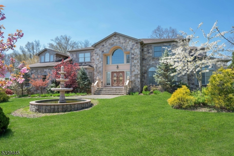 Welcome to a most unique, custom built 6200 sq ft Colonial w/soaring ceilings, stone exterior, gracious entry foyer w/bridal staircase, brass finish railings, paladian windows, gas fp w/marble raised hearth and inlaid marble carvings. The granite and stainess steel kitchen with center island, desk station, pantry and dinette area with slider door leads to the private rear yard. Dual staircase access to level two with master br w/sitting rm plus three addit'l en-suite bedrooms. The main living area boasts an open floorplan with family rm, formal dining rm, living rm, office, powder rm, laundry/mud rm plus 1st floor guest bedroom w/en-suite bath. The 3-car gar & full unf lower level complete the amenities of this special home.