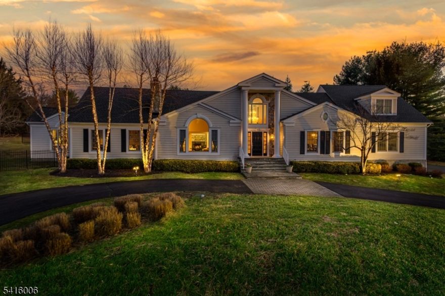 Nestled on 5 sprawling, private acres in one of Mendham borough's most sought after neighborhoods is this opulent custom colonial blending country living with modern finishes. This 5400 sq. ft. 5 bedroom spectacular home has been expertly renovated and maintained by the current owners. A long circular drive leads to the manicured property with mature trees and specimen plantings. Step inside the grand foyer with stone inlay and rounded columns to explore the beauty of this home. The 2 story living room boasts architectural moldings and details. A dramatic arched palladian window offers an abundance of natural light and stunning views. The formal dining room hosts your largest gathering and is christened with a spectacular crystal chandelier. Beyond is the designer kitchen and breakfast room, with creamy cabinetry, premium finishes and appliances. On this floor you'll find a cozy family room with gas fireplace and built in wet bar in addition to a dramatic library/offfice with coffered ceiling which provides a private entry to the primary suite. The sweeping primary suite has vaulted ceilings, a gas fireplace and a private covered patio.  The adjoining bath is fitted with white onyx, his and her vanities, a soaking tub and a steam shower. Upstairs are 4 additional bedrooms, a large sitting room and two recently renovated baths. Outdoors your private oasis awaits with a sparkling inground pool, spa, fire pit and built in kitchen. NEW 5Bd Septic, NEW Roof.