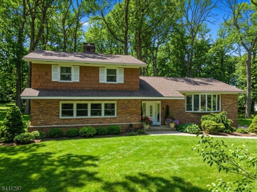 Set on 1.5 serene, wooded acres in sought-after Watchung, this beautifully updated 2,800 sq ft brick-front home offers privacy, versatility, and exceptional commuter convenience.Originally built in 1968 and thoughtfully renovated in 2019, the home blends classic architecture with refreshed interiors. Newly painted throughout with hardwood flooring across both levels, it feels cohesive, warm, and move-in ready.The multi-level layout creates natural separation for living, working, and entertaining. A dedicated first-floor office and adjacent den provide rare flexibility. The living room features a beautiful 2 sided gas fireplace, adding warmth and character.Upstairs, the primary suite includes a walk-in closet and renovated en-suite bath. Two additional bedrooms, an updated full bath, and a first-floor powder room complete the home.Outdoors, a paver patio with built-in grill station overlooks the flat, wooded acreage   offering usable space while maintaining privacy. Oversized two-car garage. Minutes to highways, NJ Transit trains and buses, downtown amenities, and area hospitals. Ideal for NYC commuters, move-up buyers, or those seeking top-rated schools in a refined suburban setting.