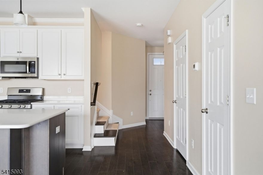 Welcome to this meticulously maintained Belmont model townhome in the highly sought-after Residences at Columbia Park, completed in 2019 and offering approximately 2,800 square feet of thoughtfully designed living space. With three bedrooms, a versatile loft, three and a half baths and a finished lower level, this residence delivers both style and function. The heart of the home features a chef-inspired kitchen with custom cabinetry, expansive quartz countertops and an oversized island with seating. The kitchen flows seamlessly into a generous living room defined by soaring ceilings and glass sliders that open to a private deck with tranquil pond views. The primary suite provides a serene retreat with tray ceiling details, a large walk-in closet and a spa-caliber bathroom featuring dual vanities and a separate water closet. Two additional bedrooms, a flexible loft space and a conveniently placed second-floor laundry room complete the upper level. The finished basement expands your living options with high ceilings, ample storage and versatile space ideal for recreation or entertaining. Columbia Park offers resort-style amenities including a fully equipped clubhouse, fitness center, outdoor pool and scenic walking paths. Perfectly positioned near Midtown Direct NYC rail service, major highways, shopping and dining, this turnkey home is ready for immediate enjoyment.