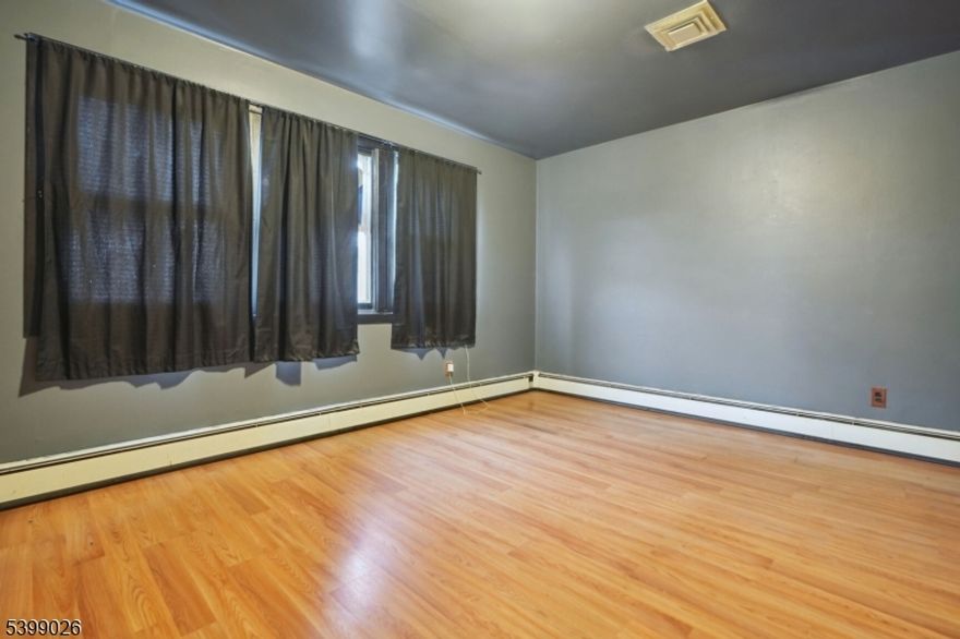 Welcome home to this spacious 4 bed, 2 bath bi-level home in highly desirable neighborhood of Paterson near the Woodland Park border. Home features large rooms, high ceilings, and custom flooring throughout. Large kitchen with 2 separate dining areas. Home also features central air conditioning as well as a 1-car attached garage. 2-car driveway. Brand new utilities installed 12/23. 2 kitchens - 1 on each level. Possible 2-family conversion, buyer to do their own due diligence. Brand new roof just installed in 2025.  Low taxes! Come and make it your own! Conveniently located near all major highways, transportation, shops, restaurants, and places of worship.