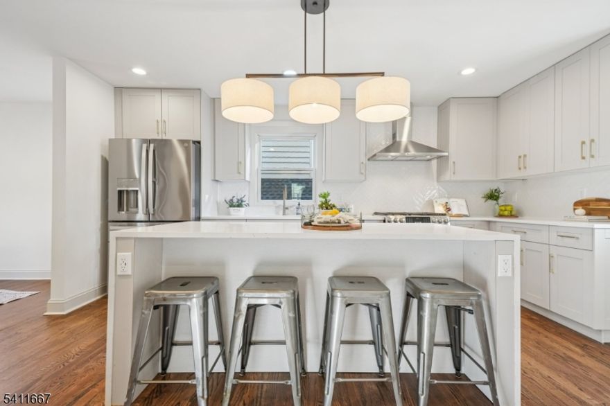 Completely Renovated Designer Home in Downtown Millburn. Located on a quiet dead-end street just steps from New Jersey's premier downtown, top-rated schools, and the NYC midtown direct train. This fully renovated and professionally designed, 4-bedroom, 4-bath home combines luxury, style, and convenience. Inside, discover an open and sun-filled layout with hardwood floors, recessed lighting, and high-end finishes throughout. The custom chef's kitchen features premium appliances, designer fixtures, floor to ceiling pantry and seamless flow into spacious dining and living areas perfect for entertaining. Adjacent to the kitchen is a full bathroom leading to a cozy den, which can double as an office or guest suite, featuring glass sliders to the backyard. The stunning primary suite boasts soaring ceilings, picture windows, a walk-in closet, and spa-like bath with double vanity, soaking tub, and an oversized shower. A finished basement offers flexible living space, while a bonus room in the attic provides added versatility. Outside, enjoy professional landscaping, a newly built two-tier backyard, and a detached two-car garage. Every detail has been thoughtfully curated to deliver modern comfort and timeless elegance, an exceptional home in one of New Jerseys most desirable locations.