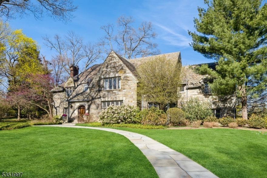 This is Essex Fells living at its most refined-masterfully crafted, pristinely maintained, and exceptionally styled. Honoring tradition while embracing luxury, 5 Beechtree is a once-in-a-generation offering. With 6 bedrooms, 3 full 2 half bathrooms, this home offers ageless appeal with fine craftsmanship in every turn. Soaring ceilings and custom woodwork, exquisitely designed and maintained gardens, this home is truly exceptional. Nestled in one of NJ's most desirable areas, Essex Fells is known for its highly regarded schools and peaceful privacy. Highlights include arched doorways, mullioned windows, stone accent walls, and elegantly scaled rooms with sweeping views over expansive lawns. The kitchen is equipped with high-end appliances, granite countertops and custom cabinetry with center island. This level includes a family room with wood burning fireplace and wood-beamed ceiling, delightful marble-floored sunroom, half bath and heated garage. Upstairs is the spacious primary bedroom complete with fireplace, a large WIC, and en-suite bathroom. 5 additional bedrooms and 2 full bathrooms complete the 2nd fl. The finished basement offers a huge rec room, game room, half bath, laundry room, and storage. The stunning landscaping is an extension of the home's charm with stone paver driveway, blue stone patios, and incredible gardens featuring specimen plantings. Whether entertaining or enjoying a morning coffee, the outdoor spaces exude unparalleled beauty, peace and privacy.