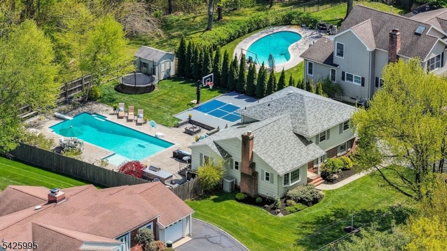 Escape the ordinary in this idyllic home, perfectly positioned on a green 1/3-acre, cul-de-sac lot. Designed for those who love to entertain and live life to the fullest, this home seamlessly blends sophisticated interiors with a backyard paradise that puts most resorts to shame.  Why book a getaway when you can live in one? This home's open-concept layout emphasizes a fluid connection between indoor and outdoor spaces, making hosting effortless and everyday life enjoyable. An expansive center island, JennAir appliances, including a 42 in refridgerator and convection oven make for a dream kitchen. In addition to three generouly sized bedrooms, a thoughtfully designed floorplan accommodates modern life, offering additional areas for a  welcoming guest suite/office/gym. The versatile layout ensures every member of the household can carve out their own sanctuary.  Here the backyard is built for year-round enjoyment - a massive inground pool  serves as the centerpiece. Elegant paver decking surrounds the pool, leading to a dedicated firepit area and built-in grill station.Sports enthusiasts will love the professional-style adjustable basketball hoop and court.