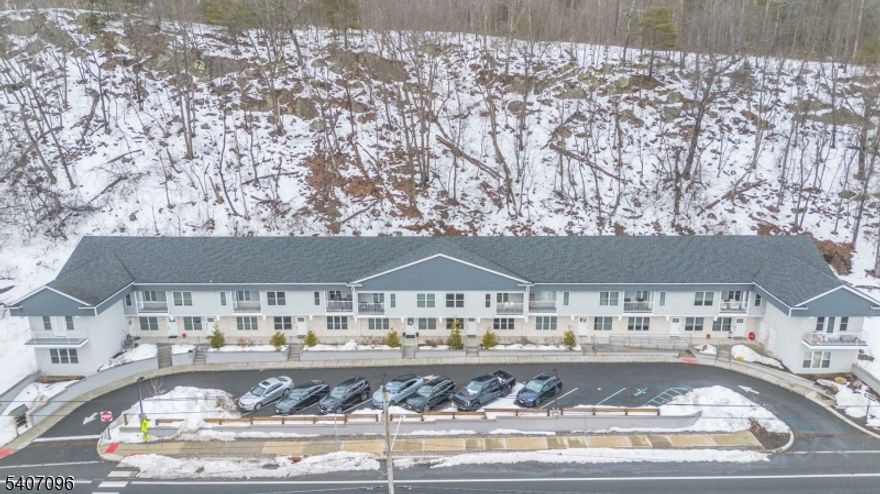 Experience elevated lakefront living in this stylish townhouse overlooking Greenwood Lake. Sunlight pours into the expansive interior, where dramatic ceiling height and a seamless layout create a bright, welcoming atmosphere. The thoughtfully designed kitchen anchors the main living space with sleek quartz surfaces, an oversized island for gathering, and exceptional storage solutions throughout the home. Generous closet space adds to the functionality and ease of everyday living. Outdoor enjoyment comes naturally with two separate porches   ideal for dining al fresco, hosting friends, or simply unwinding while taking in the view. Guest parking adds convenience. NJ Transit service offers a straightforward commute to New York City and this home is perfectly positioned near local wineries, apple orchards, and popular dining spots. Enjoy the best of relaxed lake living with everyday accessibility.