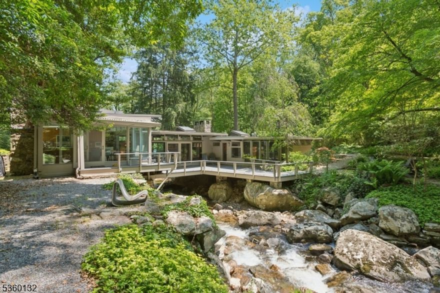 Rare opportunity to own Tewksbury's iconic "Brook House,  a one-of-a-kind Midcentury Modern home built over a stream by architect Charles Porter in 1955. Set on 5.14 private acres, this 4-bedroom, 3-bathroom home offers a harmonious blend of natural beauty and architectural design. Floor-to-ceiling windows, stone walls, and skylights bring the outdoors in, offering serene views of Hollow Brook, a waterfall, and landscaped gardens. The living room features a Zen-like ambiance with a stone fireplace, exposed beams, and wood floors. The chef's kitchen includes marble countertops, high-end appliances, and a gas fireplace. Bedrooms offer custom millwork and expansive windows. Additional features include radiant heat floors in the primary bathroom, remote-controlled heating and cooling systems, an EV charger, and video security. Outdoors, enjoy multiple decks, a stone patio, mature trees, and flowering shrubs. Conveniently located just minutes from shopping in Chester and the charming hamlets of Peapack-Gladstone and Oldwick. Only a 5-minute drive to the Gladstone train station and approximately 60 minutes to downtown Manhattan. Top-rated public and private schools nearby.