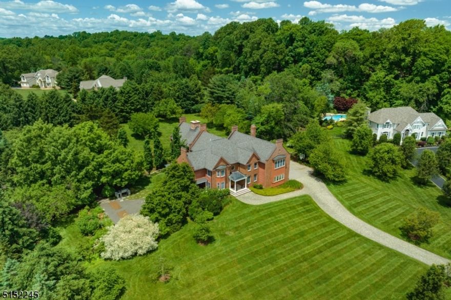 Designed by renowned architect Dennis Wedlick, this custom home offers a meticulously planned layout using the highest quality materials. The public rooms on the main level are perfect for any gathering, intimate or grand.  French doors from both the Dining Room and Great Room lead to a wraparound covered porch, providing seamless overflow when entertaining. Walnut floors grace the first and second levels, providing a rich, warm appearance. The kitchen, outfitted with high end appliances including Sub-Zero and Viking, boasts alder wood cabinetry and two center islands. From the kitchen, your gaze is drawn to the dramatic two-story timber frame constructed Great Room with Rumford double sided fireplace and chimney created using imported stone. A sweeping, iron and wood spiral staircase leads to both an upper level loft and to the finished basement. Three walls of windows, each with alder wood framing, bring the outdoors in, creating a stunning view of the grounds during any season. Upstairs, the Primary Suite offers a full bath plus a spacious dressing room with French doors leading to a balcony overlooking the side yard. Four additional bedrooms (two of which have spiral staircases to private lofts), two full baths, and a loft overlooking the striking Great Room complete the level. The finished walk-out lower level delivers a media room with two-sided gas fireplace, kitchenette, exercise room, Finlandia electric sauna,  bedroom, plus two full bathrooms.
