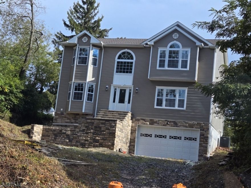 NEW HOME, Offering 5 Bedrooms 4 Full bathrooms, Finished Basement with 2 Finished Garages with opener, high ceilings in basement and first floor, Bedroom/full bathroom on 1st Floor, Luxury vinyl flooring throughout, tiled floors in all bathrooms and kitchen areas, Window seats, Plenty of recessed lighting throughout, custom bath vanities and kitchen cabinets. Custom woodwork throughout, custom painting, laundry room 2nd floor, Pull down stairs to attic storage, Convenient to NY bus/train, Taxes to be assessed being new construction, 10 Years New Home Warranty, Much more....