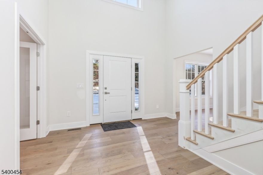 Introducing a stunning new construction home offering over 4,000 square feet of thoughtfully designed living space. This exceptional residence features 4 bedrooms and 3.5 baths, set on a picturesque one-acre lot just minutes from downtown Chester.A dramatic two-story foyer welcomes you into an open, light-filled floor plan highlighted by soaring ceilings and elegant wide-plank hardwood floors throughout. The chef's kitchen is a true showpiece, featuring a large center island with Calacatta countertops and top-of-the-line Thermador appliances. The space flows seamlessly into a sunlit eat-in area and an inviting family room with a cathedral ceiling and a cozy gas fireplace. Step out onto the deck off the kitchen perfect for outdoor dining and entertaining. Just off the foyer, a private study or home office with French doors provides an ideal work-from-home space. Upstairs, the expansive primary suite offers a walk-in closet and a spa-like bath with double vanities, a soaking tub, a stall shower, and elegant Elysian Gold countertops. Three additional bedrooms include one with an ensuite bath, along with a generous bonus room ideal for a game room, media space, or recreation area. Designer lighting from Chester Lighting enhances the home's sophisticated ambiance. Additional highlights include a heated three-car garage equipped with an electric vehicle charger. This exceptional property combines luxury, comfort, and modern convenience and is truly a must-see.