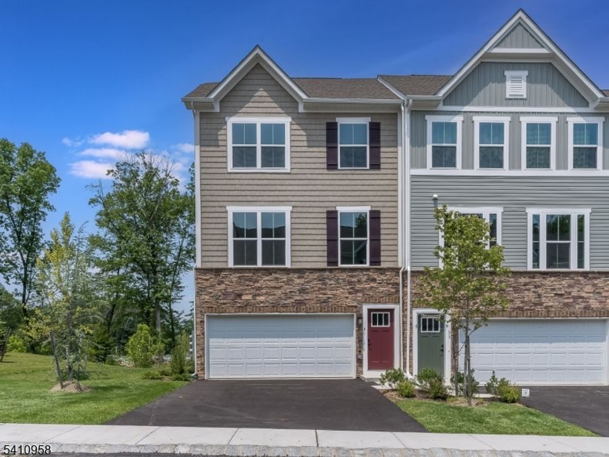 Welcome to this exceptional Shubert model end-unit townhome in the sought after Mountain Ridge Community, where style, comfort and convenience come together seamlessly.   Thoughtfully designed with an open-concept layout, the main level offers effortless flow between the living and dining areas and a beautifully appointed gourmet kitchen.  Anchored by a generous center island, the kitchen features granite countertops, stainless steel appliances and tall cabinetry - perfect for both everyday living and sophisticated entertaining.  Luxury vinyl flooring throughout the main level adds warmth and modern elegance.  Sliding glass doors lead to an expansive Trex deck, creating the ideal setting for outdoor dining or quiet evenings overlooking the surroundings.  Upstairs, the primary suite serves as a private retreat, complete with a spacious walk in closet and a spa inspired ensuite bath featuring a jetted tub, glass enclosed stall shower and dual vanity.  Two additional bedrooms, a well appointed hall bath and a convenient second-floor laundry room complete this level with comfort and practicality.  The finished walk-out lower level provides exceptional versatility, offering additional living space ideal for a media room, home office or guest suite along with a full bath and direct access to the two car garage.  Perfectly situated just minutes from Route 80, shopping, dining and everyday conveniences.  Mountain Ridge offers a clubhouse, playground and walking trails.