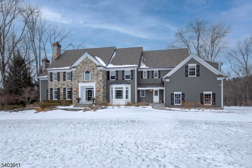 Privately nestled beyond a gated entry on one of Bernardsville Mountain's most coveted streets, this distinguished Bucks County-style Colonial offers timeless architecture and refined, updated interiors. Encompassing over 6,500 square feet plus a finished walk-out lower level, the home is both expansive and inviting.A gracious marble-floored foyer sets the tone for richly detailed living spaces where soaring ceilings, four fireplaces, and custom millwork evoke classic elegance. Recently refreshed with newly finished hardwood floors, designer lighting, and thoughtful updates, the home feels curated and current.Large windows frame views of 10 beautiful acres, drawing in light and connecting interior spaces to the pool, spa, and manicured grounds. The layout includes a vaulted family room, paneled library, butler's pantry, and spacious kitchen anchored by a 15-ft island ideal for everyday gatherings. The luxurious primary suite offers dual marble baths and a serene sitting room.With five bedrooms, multiple entertaining areas, and resort-like outdoor amenities, this is a rare opportunity to own a legacy home in one of New Jersey's most prestigious enclaves.