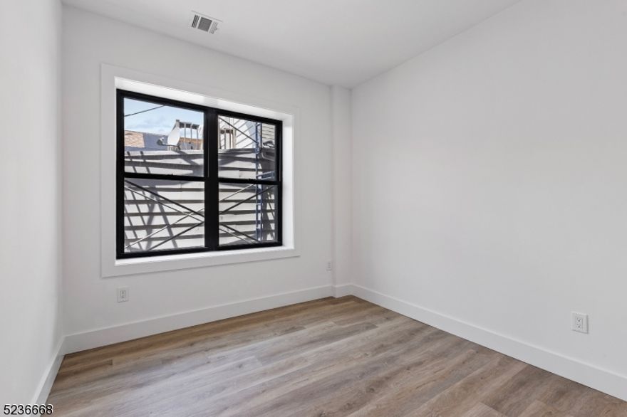 Unit 205 at Botany Gardens is a beautifully renovated 2-bedroom, 1-bath residence located in a boutique 17-unit rental building in the heart of Passaic. Thoughtfully updated with modern finishes while maintaining touches of historic charm, this inviting home offers a bright and functional layout designed for comfortable living.Inside, oversized windows fill the space with natural light, creating a warm and airy atmosphere. The kitchen features sleek quartz countertops and a full stainless steel appliance package, including a gas range oven, microwave, dishwasher, and a three-door refrigerator. Residents enjoy the convenience of central heating and cooling, as well as a stackable full-size front-loading washer and dryer right in the unit.Botany Gardens also offers a variety of shared amenities designed to enhance everyday living. Residents can unwind in the beautifully landscaped courtyard complete with lush greenery, bench seating, games, and grilling stations. Two rooftop patio decks are open year-round and provide the perfect setting to relax and enjoy the outdoors. Additional building amenities include a residents' lounge with kitchenette and a well-equipped fitness center.Ideally located near the border of Clifton's Botany Village neighborhood, Botany Gardens provides convenient access to a variety of local shopping, dining, and everyday essentials.