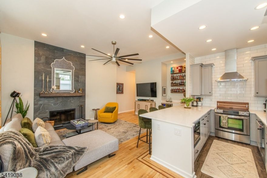 Rare Opportunity in One of Westfield's Most Sophisticated Trinity Gardens Condominium. Enjoy true one-level living in this fully renovated 2-bedroom, 2-bath corner residence with a heated garage and private backyard with expanded patio. Ideally situated just steps from Westfield's vibrant downtown with restaurants, shopping, and NYC train & bus service, this home offers an exceptional lifestyle defined by location & convenience. Filled with natural light, the home features soaring 11-foot ceilings, oversized windows, & an open-concept layout. Double French doors enhance the flow, while custom top/down light-filtering shades provide privacy & flexibility. The living area is anchored by a stunning floor-to-ceiling natural stone wood-burning fireplace, complemented by hardwood floors with a contrasting inlay border. The kitchen blends style and function with quartz countertops, full-size stainless steel appliances (range, hood, microwave drawer, dishwasher, French door refrigerator), & a large peninsula with seating for four. A dry bar with wine/beverage fridge adds ease for entertaining. Both bedrooms are generously sized with floor-to-ceiling closets & overhead storage, ceiling fans, & wall-mounted sconces. The primary bath features a jacuzzi tub, LED medicine cabinet, towel warmer; the hallway bath offers a walk-in shower and towel warmers, upgraded hydronic baseboard heating with Wi-Fi controls, three wall AC units, recessed lighting & two ceiling fans.