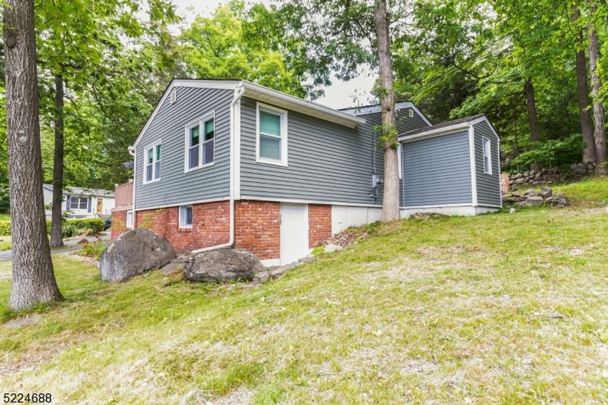 Welcome to beautiful Scenic Lakes! Conveniently located off route 23. Indulge in the tranquility of this charming neighborhood with a wonderful lake view and very close to the beach. renovated in 2019 this open-concept, corner lot ranch is situated on nearly a 1/4 acre of land and features high ceilings, recessed lighting, and a cozy wood-burning fireplace. Create lasting memories with friends and loved ones around the breakfast bar or dine in the generous dining area. The expansive modern kitchen is equipped with SS appliances, ample counterspace, and two spacious pantries. The heating and cooling, ductless mini-split system supports eco-conscious living and cost savings that reduces the reliance on fuel oil. The lake-facing primary bedroom is full of natural light and the ensuite boasts a beautiful walk-in shower. Enjoy the natural beauty of the outdoors on either the private patio or the lake-facing deck. The lower level of the home is accessible from outside and contains the oil tank, water heater, well equipment, as well as an additional area that can be utilized as extra storage or a workshop. Newer washer and dryer on the main level.  Nothing left to do, but move in!