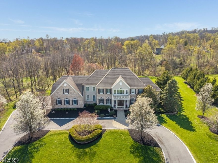 This stunning Colonial in desirable Milestone at the Glen offers 5,788 sq ft of living space with 14 beautifully appointed rooms, & a finished basement (approx. 1,450 sq ft).  Featuring 4 spacious bedrooms and 5.5 baths, this home blends luxury, comfort, and thoughtful design throughout. The main level showcases a stunning staircase, gourmet kitchen upgraded in 2024, complemented by a sunlit breakfast room with a double-sided fireplace. A dramatic family room with coffered ceilings & a gas fireplace creates a perfect gathering space, while the conservatory and 1st floor office provide flexibility for work and relaxation. Formal living & dining rooms, along with front and back staircases, extensive mill work, classic detailing and hardwood floors throughout add to the appeal. Upstairs, the primary suite is a private retreat featuring a walk in closet & dressing room with custom cabinetry, sitting room with double-sided fireplace, tray ceiling, and a luxurious bath with jetted tub. Three additional bedrooms each include their own ensuite bathrooms & walk in closets, while the 4th bedroom has adjoining area with electric providing the opportunity to finish. The finished walk-out basement is designed for entertaining and lifestyle, with a bar, media room, game room full bath and office. Outdoor living is equally impressive, featuring a multi-level paver patio with a hot tub terrace, kitchen area, fire pit, and a tranquil waterfall pond perfect for both relaxing and entertaining.
