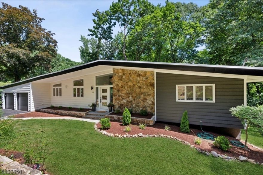 Stunning and FULLY RENOVATED! this classic mid-century modern Ranch blends modern convenience, luxury and designer finishes throughout. This property boasts views of the Springbrook Country Club and NYC skyline, and is ideally located near downtown shopping and dining, top schools, highways, and NYC direct train options for easy commutes. Inviting foyer with chandelier opens to a top of the line chef's kitchen w/2-tone soft-close cabinets, sleek farmhouse sink, Italian tile, premium Bosch + Sharp appliances, a cozy breakfast nook, and convenient access to the 2-car attached garage with insulated doors and high tech surveillance cameras. Breathtaking living room w/hardwood floors, walls of windows and a gorgeous fireplace in a stone feature wall shared with the adjacent formal dining room. Two sets of sliding doors lead to a wrap-around balcony for where you can have a cup of coffee or cocktails while enjoying the view. Wood floors continue to 3 large bedrooms including a primary w/2 closets and an en-suite bath with Italian tile skylight, and shower. A second full hall bath has dual vanity, skylight, and a jetted tub. There's more living space for relaxing or entertaining in the lower level, offering a family room with stone fireplace, wet bar, and sliders out to a new paver patio. A bedroom, half bath, laundry room, and utilities to complete the interior. Major updates include NEW Roof, AC handler/condenser, front door, skylights in full baths, resurfaced driveway and more.