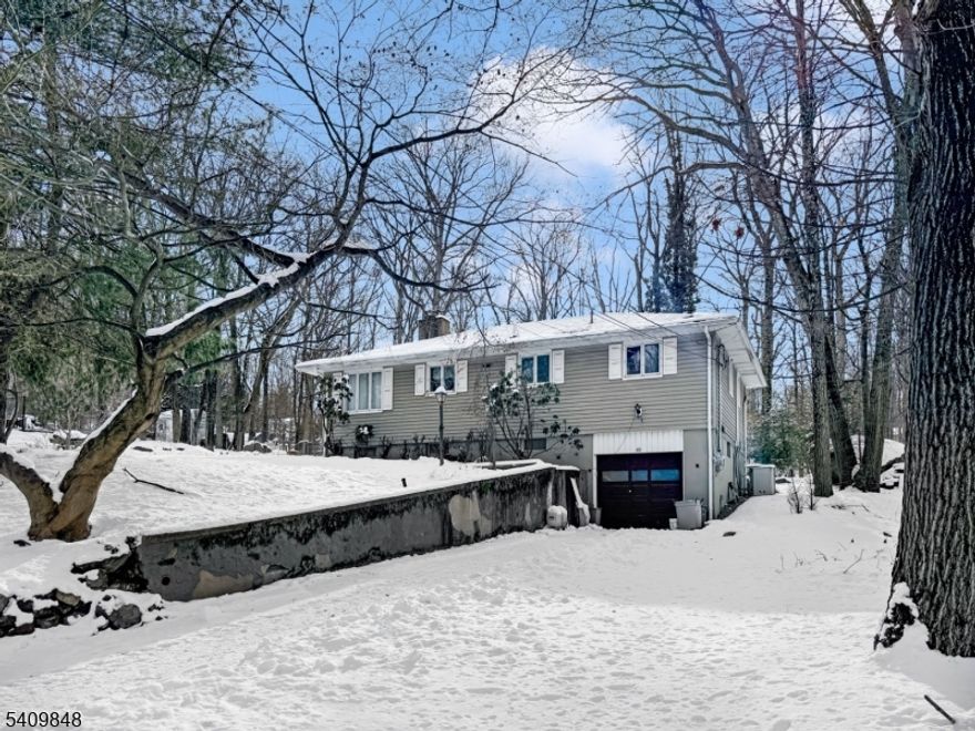 Hidden paradise best describes this home on a double, separate-deed lot measuring 120x240, featuring blue stone patios, a built-in stone barbecue grill, a waterfall, and a pond. Beautifully maintained, the kitchen includes newer cherry cabinets, granite tops, and new appliances. The living room is warm and inviting with hardwood floors throughout and a wood-burning fireplace. The full bath is also new, with Wane's coating and a large linen closet. The fully finished walkout basement features built-ins, a wet bar, a recreation room with a gas fireplace, an office or den, and a laundry room. Half of the one-car garage has been converted into an office, but can easily be changed back. ATTENTION BUILDERS: Buy and build a house on the adjacent lot.