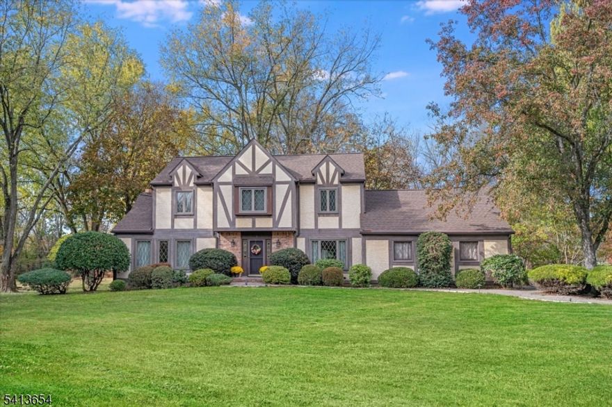 Classic Tudor charm set on nearly one acre in a sought-after Branchburg neighborhood. Lovingly cared for by the original owners, this spacious 5-bedroom, 2.1-bath home offers timeless character, beautiful curb appeal, and a warmth that is felt the moment you arrive. A welcoming foyer opens to a light-filled interior featuring two coat closets and formal living and dining rooms. The eat-in kitchen flows directly into the den with a gas fireplace, creating a comfortable space for everyday living. A rare first-floor bedroom offers exceptional flexibility for guests or a home office. Upstairs are four additional bedrooms, including a spacious primary suite with ensuite bath, walk-in closet, and a dedicated vanity area. Important updates have already been completed, including a new roof and siding (Aug 2024), refinished hardwood floors (2026), and a water heater (Dec 2025). The backyard is a standout, featuring unique park-like privacy, a rear patio, a two-car attached garage, and ample driveway parking. Ideally located just 0.6 miles from the elementary school, with easy access to major highways, shopping, and dining. The home is comfortably move-in ready while offering the opportunity to bring your own design vision over time - Welcome Home!