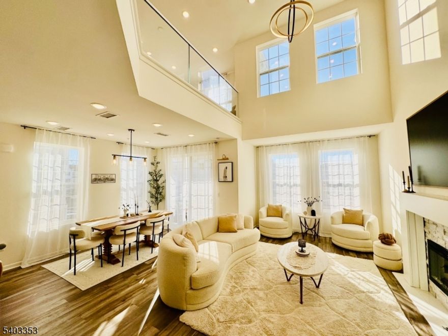 Welcome to this beautiful end unit townhome in the highly desirable Crossings at Dunellen. This stunning, sun filled home features 3 spacious bedrooms, dedicated office space, and 2.5 bathrooms. Abundant windows throughout fill every level with natural light, creating a warm and inviting atmosphere. The ground level includes an attached garage and additional parking for two vehicles. The first floor offers an open concept layout with a spacious kitchen featuring stainless steel appliances, a breakfast bar, and ample cabinetry. The kitchen flows seamlessly into elegant living and dining areas highlighted by a dramatic two story ceiling. Sliding glass doors lead to a private balcony, perfect for relaxing, and a convenient half bath completes this level. The second floor features a primary suite with a spa like bathroom offering a soaking tub and separate shower, plus a large walk in closet. Two additional generously sized bedrooms with walk in closets share a full bath. This level also includes an open loft family room overlooking the great room, an additional den or office, and a laundry room. This modern community, located in the heart of Dunellen, offers resort style amenities, including a swimming pool, fitness center, and clubhouse, an unbeatable location near train and bus stations, just 0.3 miles (6-minute walk) close to Route 22, shopping, and with private access to Columbia Park. Pets may be considered case by case. Don't miss this opportunity, schedule showing today!