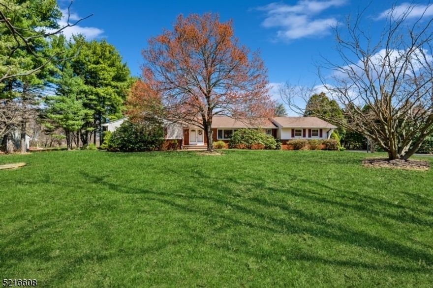 Bright and spacious home close to nature! Well-maintained Ranch home with four bedrooms and two and a half bathrooms is nestled on nearly one and a half usable flat acres of private property in central Morris County about fifty miles west of New York City. Highlights include, one floor living, 2 fireplaces, generator hookup, easy conversion to public water. Convenient to shopping, restaurants, and businesses, this home is just minutes to Route 80 and directly across the road from a sprawling, scenic park. The light-filled foyer with a skylight opens to a large living room and dining room combination. The bright kitchen features granite counters, ample cabinet and counter space, a generous breakfast nook, and a cozy white brick fireplace. Sliding glass doors open to a large deck overlooking the deep back yard perfect for gatherings, gardening, and relaxing. Off the kitchen is a half bathroom with a washer/dryer and access to the attached two-car garage. Down the hall is the large primary bedroom with a private full bathroom, three additional bedrooms, and another full bathroom in the hallway. The finished basement offers a great space for entertaining with a large wet bar, lounging area, and another warming fireplace. An office space can be created next to the extensive built-in bookshelves, along with a workshop, a walk-in cedar closet, and lots of extra storage.