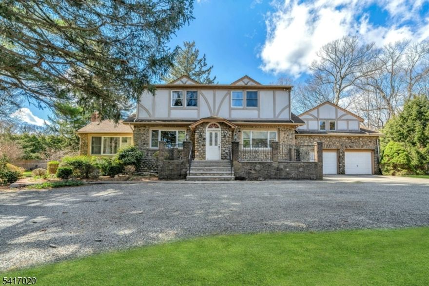 Stately manor-style home built in 1929 and part of Franklin Lakes? original residential landscape, offering timeless character on a picturesque property of over an acre with mature trees and sweeping lawn. A circular driveway, charming fountain, and inviting front porch create impressive estate-like curb appeal.Gracious living spaces include a family room with raised beamed ceiling and gas fireplace, and a dining room with a second fireplace. The spacious eat-in kitchen and generously sized bedrooms offer excellent scale, including a primary suite and a separate en suite?ideal for guests.A rear foyer off the kitchen provides access to the deck with electric awning and expansive side yard areas. Two fenced areas create space for gardening and a dog run. With some updating, this distinctive property presents a rare opportunity to personalize a classic residence in one of Bergen County?s most desirable communities. Timeless architecture, warmth, and exceptional potential define this special offering.