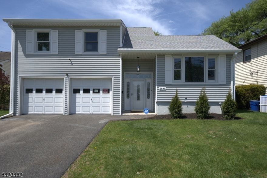 Impeccably fully renovated split-level residence offering an ideal combination of space, style, and convenience. This home includes 4 bedrooms and 3 full baths, highlighted by a well-appointed in-law suite with a full bathroom. The modern open-concept floor plan showcases sleek finishes and hardwood flooring throughout. Additional highlights include central air and heat, a fully finished basement designed for entertaining, and major upgrades such as a new roof, new electrical system, and new plumbing. The home is further enhanced by a security system and appliances under warranty for peace of mind. The property is complete with a spacious backyard, a two-car driveway, and an attached two-car garage. Located just moments from the NYC bus line for an easy commute. A must see! It won't last!