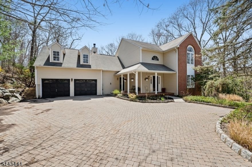 Leave your cares behind as you make your way down the long driveway to this peaceful retreat. Enjoy the serene woodland setting while relaxing on the wrap-around front porch. A two story entry foyer opens to an elegant living room and dining room with custom, paneled wainscoting. A fully-appointed kitchen features granite countertops and stainless appliances. Kitchen opens to a breakfast room with sliders to a deck and a sun-drenched family room with two-story ceiling height, wood-burning fireplace, and sliders to the deck. First floor laundry, powder room, and garage access offer much-desired convenience. Second floor master suite has it all: walk-in closet, large bathroom with soaking tub, and tree-top, wooded views. Second floor has three additional, generously-sized bedrooms, one separated by a long hallway overlooking the family room. Gorgeous hardwood floors throughout first and second floors. Ground floor features large recreation room, office space, full bath, and two storage rooms. Possibility of multi-generational living with private entrance to large ground floor living space. Great space for outdoor entertaining: level play area, large deck, and side patio. This home is township living at its very best.