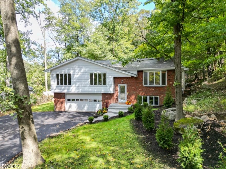 Prepare to be amazed. Over 5000 sq ft .This Custom multi generational 5-bedroom home w/ additional lower level living space has 6 full baths, 9 zone heating & a/c along with a two car oversized garage has it all. Brand new kitchen upstairs with tile floor, Calacatta quartz countertops, soft close cabinetry and new SS appliances that lead to a large deck. Gleaming H/W floors. Two large suites on the second level. M/B with jetted tub and separate shower and all in one remote control toilet w/ bidet. Huge w-i-c closet and windows that look out to the backyard. Junior suite has a walk-in closet and full bath with jetted tub & shower combo as well as remote control toilet w/ bidet. L/R w/ electric fireplace that changes colors to create a beautiful ambiance. D/R, Butler's pantry with wine fridge and three additional bedrooms on the other side one with its own bathroom and 1 additional bathroom has a tub shower combo for the other two bedrooms and a remote control toilet w/ bidet. The elevator completes the second floor. The 1st level has an entrance from the garage or the side of the house. You enter into the L/R with D/R and kitchenette w/ new countertops and SS fridge. First floor has tile floors in the bedroom with a steam shower and remote control toilet w/bidet. Huge library/ office or bedroom. Laundry room, workshop and utility room along with an elevator complete the first level.  Brand new 5-bedroom septic installed along with city water August 2023. Whole house generator.