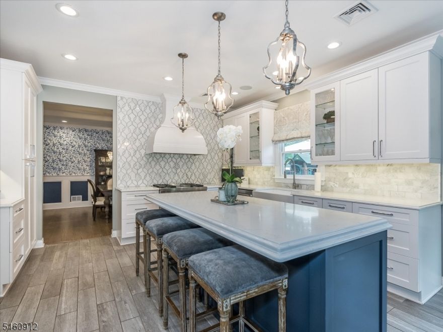 Picture-perfect newer built classic colonial with 5 bedrooms 3 full baths and 2 half baths. Impeccable attention to detail from the stunning white kitchen to the professionally landscaped and fenced in yard, the open floor plan of the home is ideal for entertaining. Walk right into the large foyer, French doors lead to the first floor bedroom which is currently being used as an office. Formal Living Room and Dining Room with beautiful detailed millwork. The large white kitchen has white quartz countertops with marble backsplash, with a large oversized midnight blue island which can seat 4.The Family Room has a marble gas fireplace. The second floor features 5 bedrooms, and a gracious Primary Suite with vaulted ceilings and 2 custom built in closets. Primary bathroom has large oversized double vanity, jacuzzi tub, flatscreen TV, and shower with hand held shower head, rain shower head and 4 water massagers. Second floor laundry, 4 other bedrooms and 2 full baths round out the second level.  Finished basement has 9 foot ceilings, a work out/gym space, a Kitchenette, rec area play and a half bath. Tankless hot water heater. Garage has very high ceilings and built in loft for extra storage. Outdoor TV on deck. Truly a must see, lots and lots of fresh updates to please today's buyer!