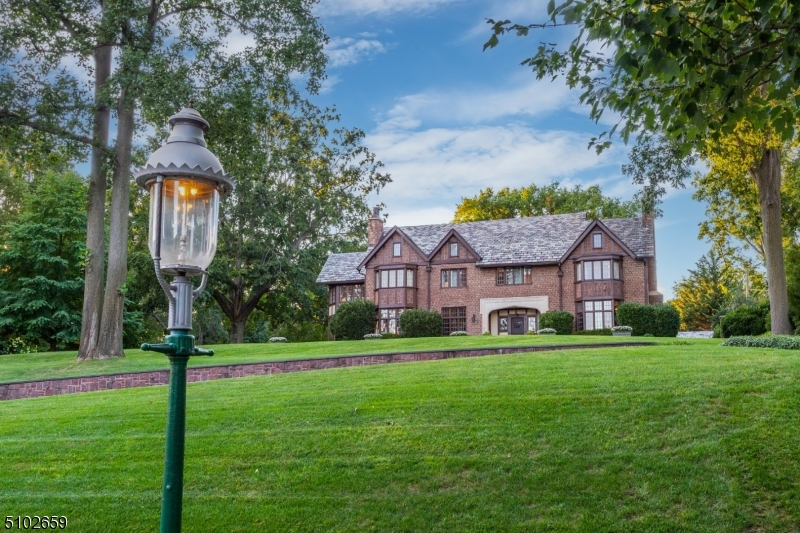 Welcome Home to this stunning 1923 Tudor Revival on magnificent 1.8+ acre property w/spectacular gardens, sports court, sparkling pool & beautiful pool house w/shower, bath & kitchenette. Respectfully maintained & brilliantly renovated w/gorgeous architectural details & contemporary upgrades throughout.  6 FPs, oak paneling, extraordinary millwork & impressive leaded glass. 1st floor offers wonderful Library/Fam Rm, generous LR, Sunroom, DR, Butler's pantry & chef's kitchen w/breakfast room.  2nd floor features romantic primary BR w/FP, sitting room, 2 walk-in closets & luxurious bath plus 3 more BR's, all ensuite.  3rd Floor has 2 BRs & large Fam Room. Gracious living in an unbeatable location just .3 miles to NYC direct train, close to highly rated schools & views of NYC. You can have it all!