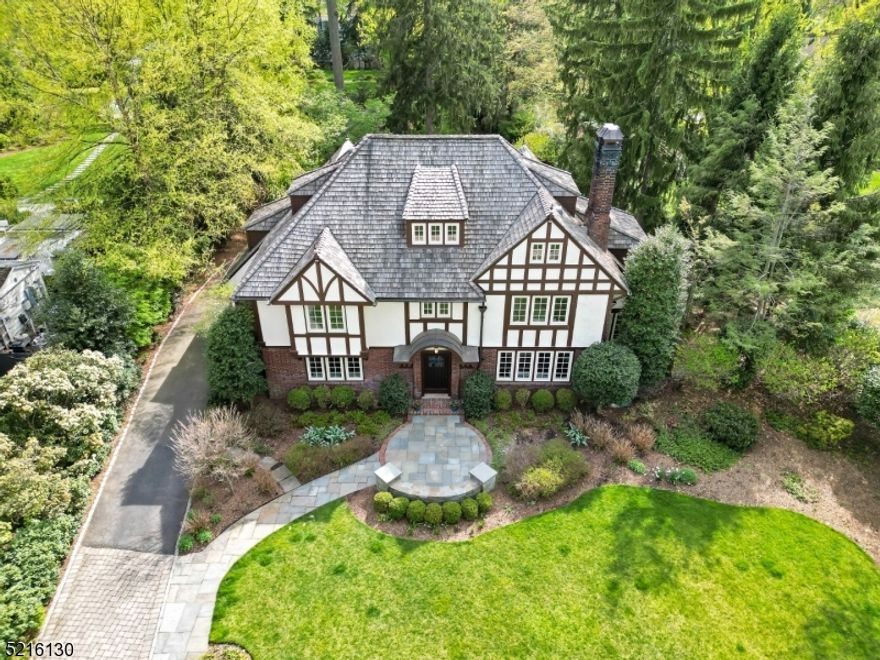 Marvel at this spectacular Colonial set in park-like grounds on a much-favored street in Montclair's Estate Section.  This fine home has everything for a comfortable modern lifestyle.  As you enter the Foyer, notice the beautiful new floor that sets the tone for the rest of this gorgeous residence. Bring your favorite recipes to Chef's Kitchen with recently repainted cabinetry, top-of-the-line appliances & new hardwood floor. Entertain in the gracious Dining Room that enjoys easy access to the Kitchen. The beautiful Living Room is spacious with a wood-burning fireplace and adjoins the sunny Family Room, with easy access to the massive Blue Stone Terraces. The Primary Suite boasts Bedroom, Sitting Room, Fitted Dressing Room, and Ensuite Bathroom. There are four more bedrooms and three more FULL baths. Enjoy your private Gym complete with a steam shower.  Wash day will be a joy in the best-equipped Laundry Room possible. Relax & take in a movie in the state-of-the-art Media Room.  Indulge yourself and your guests in the impressive Wine Center.  The level acre park-like grounds, designed and maintained by noted gardeners, include an irrigation system and lighting. There is an English Boxwood Garden, a Mediterranean Garden and yes a Badminton Lawn. This home has been immaculately maintained, and the mechanical and technical aspects are all at the highest level.  Live your best life is this exceedingly appealing home!