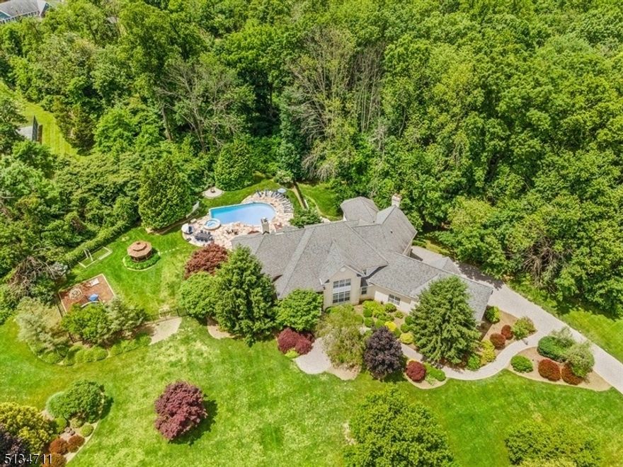 Luxurious 7000+ square foot estate nestled upon 7 acres with endless amenities at Ravenswood. This stunning home boasts high ceilings,custom millwork throughout and an incredible gunite heated pool and jetted spa to compliment the outdoor granite grill, refrigerator, and 4 season sunroom. The chef's kitchen is equipped with Viking, Electrolux and Sub Zero appliances along with a center island and additional dining space. The formal dining room is outfitted with custom millwork that continues past the double front doors up to the  primary bedroom.  In the primary bedroom, there is a custom closet/sitting area and a walk-in steam shower and jetted tub. The lower level consists of a theater room with stadium seating, full gym, and temperature controlled wine cellar. The 4 car garage with electric car hook-up leads to a mudroom and laundry room. Top rated Bernards school district. Close to NYC transportation and multiple train stations. This home is not to be missed