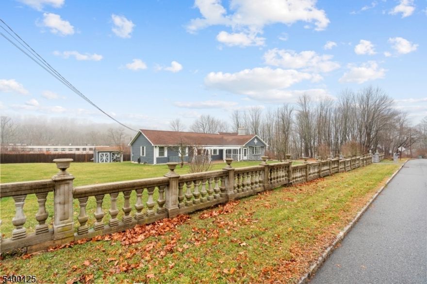 Stunning 2,960 sq. ft. custom-built, fully renovated, expanded ranch-style 5-bedroom, 3-full-bath mother/daughter home on nearly one acre with IE commercial zoning. Features premium 400 Series Andersen windows, hardwood floors, recessed lighting, 5-inch moldings, and a wood-burning fireplace with insert. The gourmet kitchen offers quartz countertops, an island and peninsula, cabinets with lighting and frosted glass doors, a farmhouse sink, full ventilation, and a custom range hood, along with a separate eat-in kitchen and dining room. The luxurious primary suite includes heated bathroom floors, heated towel racks, a quartz double-sink vanity, walk-in shower with bench, jetted Jacuzzi tub, and a spacious walk-in closet. The main bath features a glass shower door, built-in assistance seating, and defrost mirrors. The walk-out basement provides a full mother-in-law suite plus a separate cellar room. Outdoor living is exceptional with an above-ground pool, a zero-maintenance deck with vinyl railings, maintenance-free siding, and electrical setup for indoor/outdoor entertainment, including projector capability. Additional highlights include an oversized two-car garage with a loft, natural gas, well water, public sewer, and a walk-up attic. A truly one-of-a-kind property with exceptional upgrades and endless potential. Oversized garage with ample space suitable for parking a commercial vehicle.