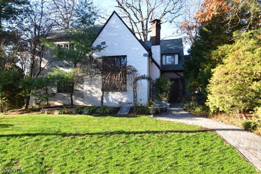 Enchanting Tudor in Knollwood section, just blocks to Millburn & Short Hills direct train stations to NYC.Romantic Juliet balcony overlooks dramatic living room. Addition & Renovation 2012, stunning chef's kitchen w/center island, separate built-in seating area, granite counter tops, stainless-steel appliances incl dual fuel double oven & 5-burner gas range, butler's pantry/home office, charming dining room w/exposed brick wall & flagstone floor, remarkable 2 story leaded & stained glass windows in beamed cathedral ceiling living room w/wood-burning fireplace & Juliet balcony, powder room, bedroom #5 en suite to full bath w/double entrance, & access to rear gardens.The 2nd level provides 4 bedrooms: new primary suite with oversized outfitted closet & spa-like onyx full bath w/jetted tub. 3 additional bedrooms share a newer full bath, 4th bedroom boasts a powder room.The lower level offers a media/rec rm, laundry rm w/2 W/D, large storage room & utilities, & door to attached 1-car garage.Incredible charm including original chandelier, wall sconces, beams, wood trim, hardwood floors. Private rear gardens & deck. The driveway allows for multiple cars to park. Updated: roof, 200 amp electric plus sub-panel, 2 boilers, hot water heater, thermal windows. Busing available to Hartshorn Elementary, 3 blocks to Millburn Middle School, & 5 blocks to award-winning Millburn High School. Just blocks to vibrant downtown Millburn, NYC trains, South Mountain Reservation & Paper Mill Playhouse